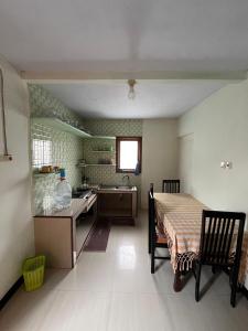 a kitchen with a table and a sink and a table and chairs at Widodaren Homestay in Probolinggo