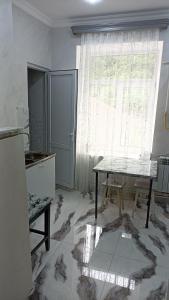 a kitchen with a table in front of a window at Bnakaran dzoragetum in Dzoraget +10 photos