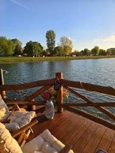 a wooden deck with chairs and a view of a lake at Domček na vode 5 in Senec