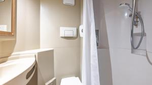 a bathroom with a shower and a toilet and a sink at Premiere Classe Lyon Ouest - Tassin in Tassin-la-Demi-Lune +16 photos