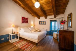 a bedroom with a white bed and a wooden ceiling at Castello Di Postignano Relais in Sellano