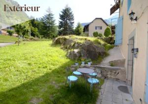 a table and chairs in a yard with a field at Apt 5 Eaux-Chaudes proche Laruns et Espagne in Laruns