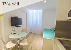 a small room with a table and chairs and a tv at Apt 5 Eaux-Chaudes proche Laruns et Espagne in Laruns