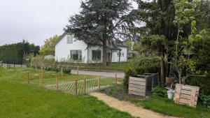 a white house with a fence in front of a yard at Guesthouse 10 in Schellinkhout