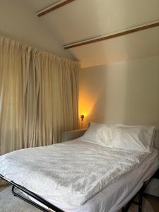 a bedroom with a bed with white sheets and a window at B&B Sonnegaerde in Arnhem