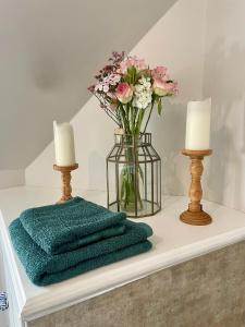 a vase of flowers on a table with two candles at Room 2, Wedale House in Stow +22 photos