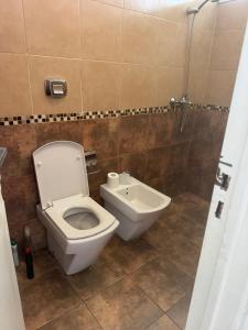 a bathroom with a white toilet and a sink at Casa Mirador del Lago in Villa Parque Siquiman