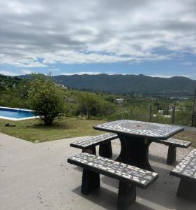 a picnic table and benches with a view of a pool at Casa Mirador del Lago in Villa Parque Siquiman