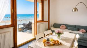 a living room with a table and a view of the ocean at Terrazzo Panoramico Fronte Mare Zamponi in Civitanova Marche