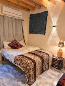 a bedroom with a bed and a lamp and a window at Omar Cozy in Dahab