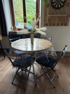 a glass table with two chairs and a vase on it at En prairie in Malmerspach