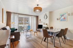 a dining room and living room with a table and chairs at Les Gemeaux 2 - 6 personnes in Villard-de-Lans