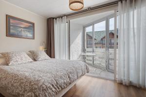 a bedroom with a bed and a large window at Les Gemeaux 2 - 6 personnes in Villard-de-Lans