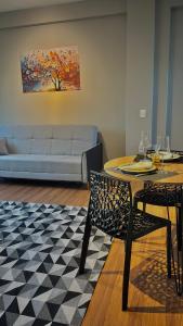 a living room with a couch and a table and chairs at Residencial Zoe 102 in Foz do Iguaçu