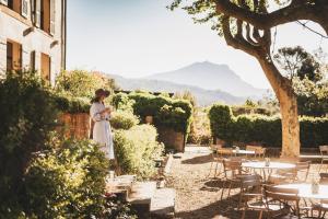 a woman in a white dress standing in a garden at Les Lodges Sainte-Victoire Hotel & Spa in Aix-en-Provence