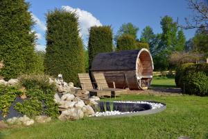 a garden with a hobbit house and a pond at Insolites à Chimay - Les roulottes à Rièzes in Chimay