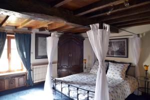 a bedroom with a canopy bed with curtains at Insolites à Chimay - Les roulottes à Rièzes in Chimay