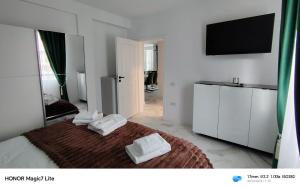 a bedroom with a bed with two towels on it at Zori de Bucovina Apartament in Gura Humorului