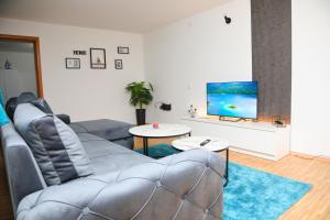 a living room with a couch and a flat screen tv at City Apartman 101 in Bosanski Brod