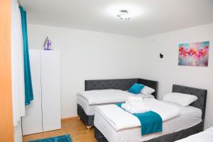 two beds in a room with white and blue at City Apartman 101 in Bosanski Brod
