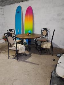 a table and chairs with surfboards on a wall at SWELL house, EL TUNCO in El Sunzal
