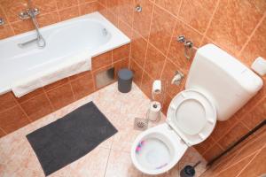 a bathroom with a toilet and a sink and a tub at City Apartman 101 in Bosanski Brod