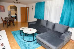 a living room with a black couch and a table at City Apartman 101 in Bosanski Brod