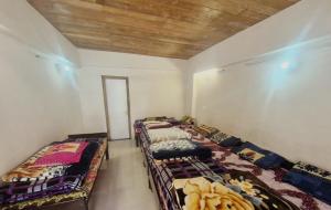 a room with three beds in the corner of a room at Explore bharat in Kedārnāth