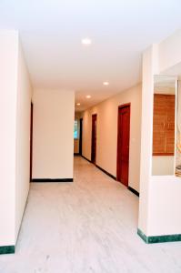 an empty room with white walls and red doors at Raamspark in Tiruchirappalli