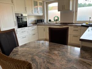 a kitchen with a large marble table and chairs at Ferienwohnung Haus Lohne in Lohne