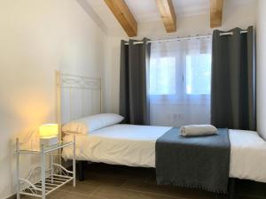 a bedroom with two beds and a window at Homenfun Vila Badalona in Badalona