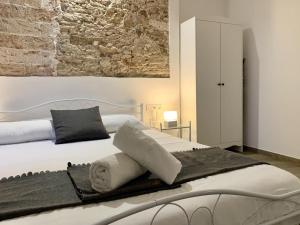 a bedroom with a white bed with towels on it at Homenfun Vila Badalona in Badalona +2 photos
