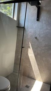 a glass shower in a bathroom with a toilet at Residencial Zoe 102 in Foz do Iguaçu