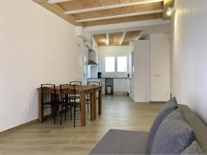 a living room and kitchen with a table and chairs at Homenfun Vila Badalona in Badalona