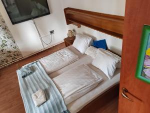 a bed with white sheets and pillows in a room at Guest Zimmer Nora in Zamárdi +2 photos
