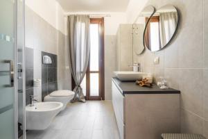 a bathroom with a sink toilet and a mirror at Casa Claudia in Elmas