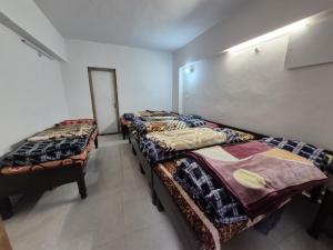 a room with three beds in a room at Explore bharat in Kedārnāth