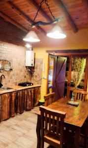 a kitchen with a wooden table and a sink at Aypa Pacha Nono in Nono +10 photos