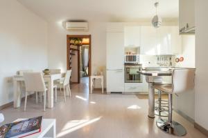 a kitchen with white cabinets and a table and chairs at Casa Claudia in Elmas