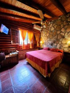 a bedroom with a large bed and a stone wall at Aypa Pacha Nono in Nono