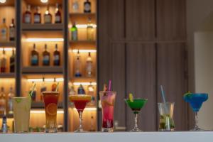 a row of different colored glasses sitting on a bar at WOODSY Resort in Nanyuki
