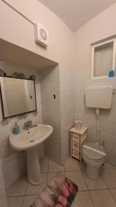 a bathroom with a sink and a toilet and a mirror at Il Caruggio in Cabella Ligure