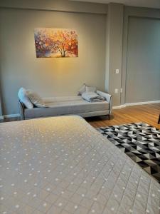 a living room with a bed and a painting on the wall at Residencial Zoe 102 in Foz do Iguaçu