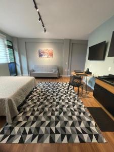 a room with a bed and a couch and a table at Residencial Zoe 102 in Foz do Iguaçu