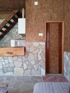a room with a stone wall and a door at -DO- Gradac in Šavnik