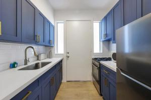 a kitchen with blue cabinets and a stainless steel refrigerator at 8040 Harding Apts in Miami Beach