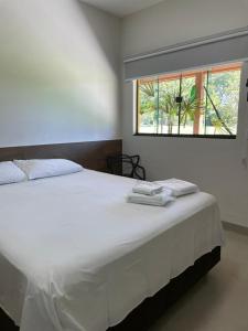 a bedroom with a large white bed with a window at Hotel Camping R Formoso in Bonito +36 photos