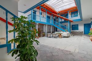 ein großer Raum mit blau-weißen Wänden und einer Pflanze in der Unterkunft LA RAMBLA Hotel Boutique - Cusco in Cusco
