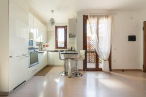 a kitchen with white cabinets and a table in it at Casa Claudia in Elmas +19 photos