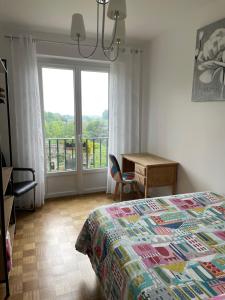 a bedroom with a bed and a desk and a window at Le Relais Médiéval in Fougères